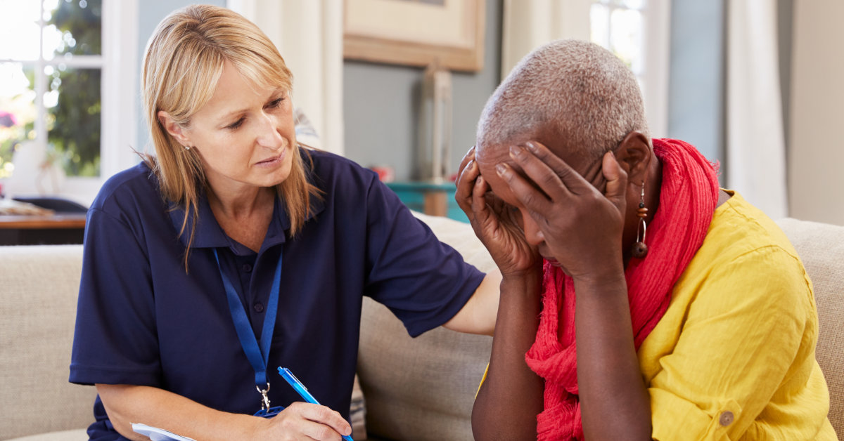 A social worker engaging in trauma-informed care with an elderly client