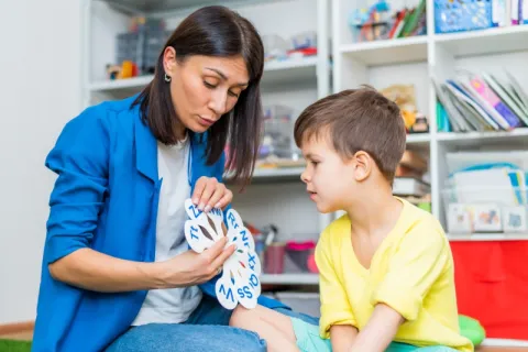 A female SLP working with a young client